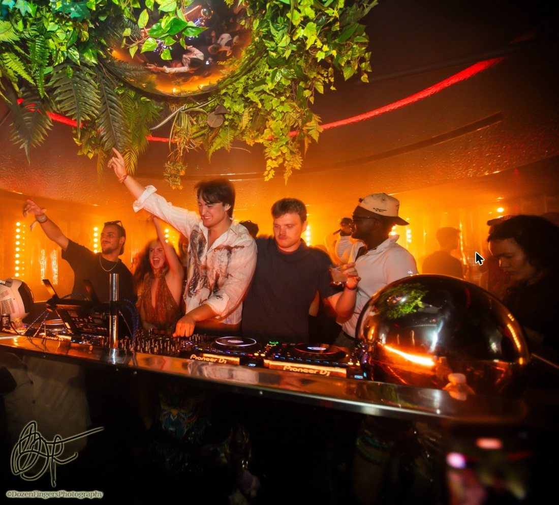PREWAR in the DJ booth at Unveiled under hanging plants
